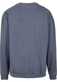 Szürke pulóver sima textúrával, bordázott nyakkal és mandzsettával. Az alja rugalmas, és nincsenek látható logók vagy minták.