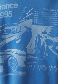 Blauwe katoenen t-shirt met een grafische print van raceauto's en een racebaan, met de tekst "Frankrijk 1995" en evenementdata in het wit.