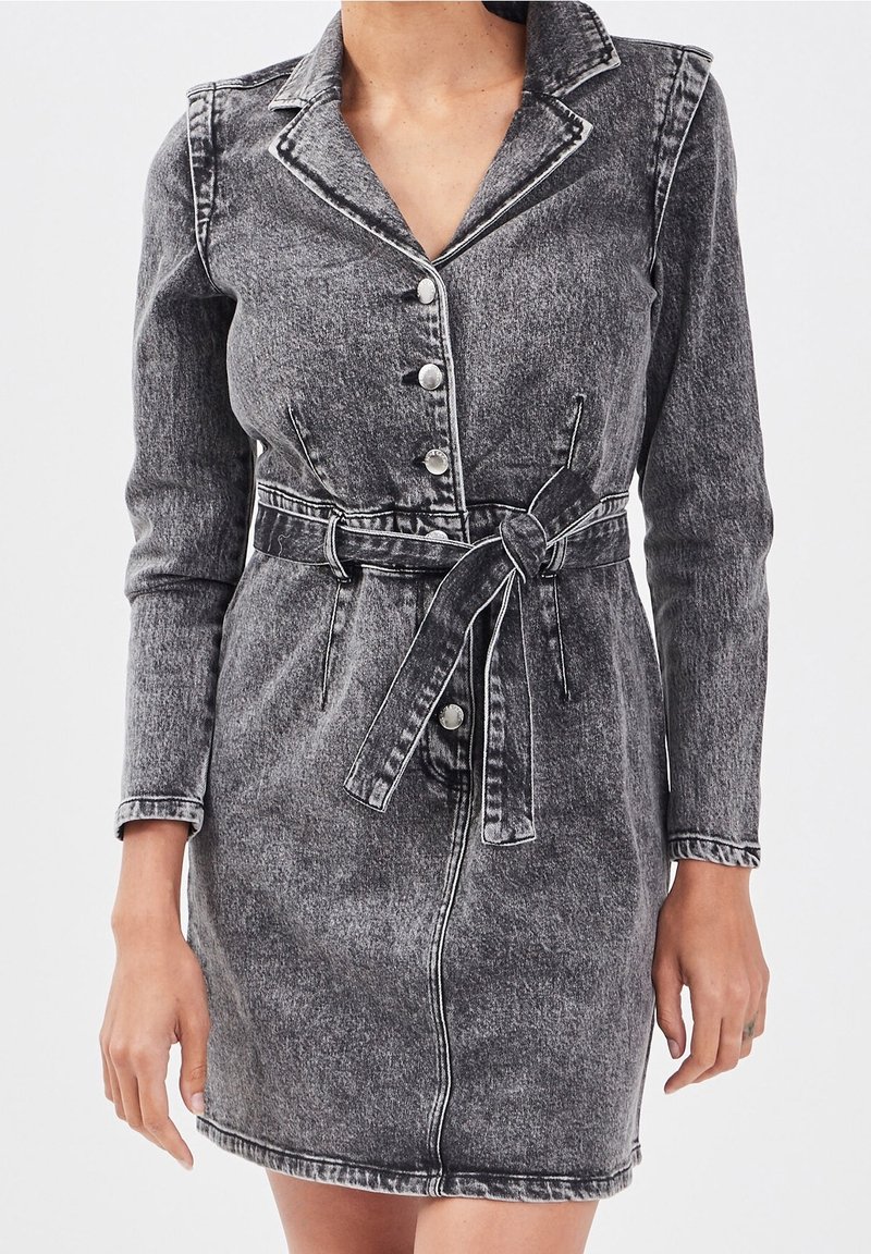Robe en denim noir délavé avec manches longues, coupe ajustée, col, boutonnage sur le devant et ceinture en tissu. Présente des coutures contrastées et une texture subtile.