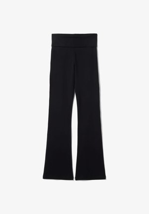 Pantalones de yoga negros de tiro alto con una cintura ancha y piernas acampanadas, extendidos sobre un fondo blanco.