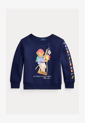 Námornícky modrá mikina s medvedíkom Polo v námorníckom oblečení, ktorý drží námorné vlajky, text "POLO RALPH LAUREN" na rukáve a logo pod medvedíkom.