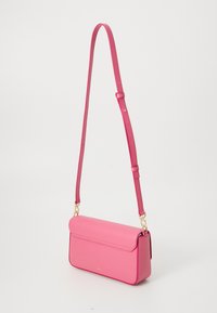 Pink leather crossbody bag with a flap design, gold hardware accents, and an adjustable strap. Smooth texture and rectangular shape.