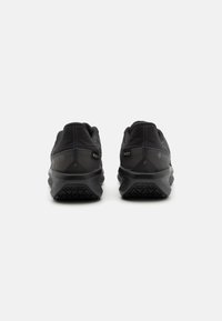 Chaussures de randonnée noires avec une finition texturée, dotées d'une semelle rembourrée, de renforts au niveau du talon et des orteils, et d'une marque Gore-Tex sur le côté.
