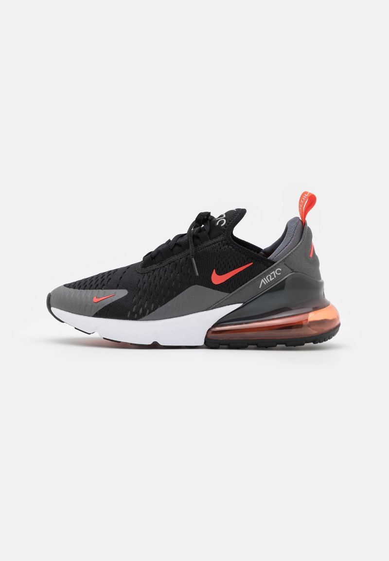 Schwarze Sneaker mit Obermaterial aus Mesh-Gewebe, grauen Akzenten, rotem Nike-Logo und sichtbarer Luftpolsterung in der Ferse. Weiße Zwischensohle und schwarze Gummisohle.