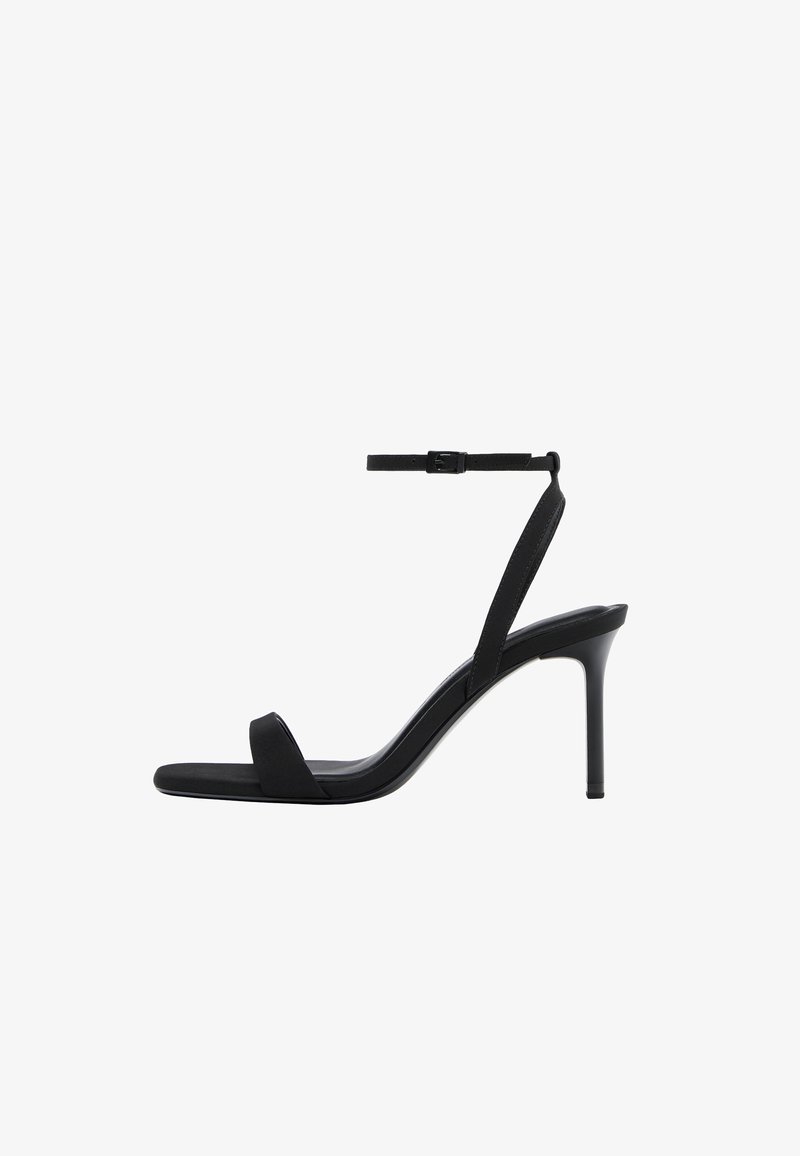 Sandalo nero con tacco alto, cinturino sottile alla caviglia e punta aperta, caratterizzato da un tacco a spillo sottile e un design minimalista.