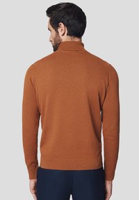 Brązowy sweter dziany z wysokim kołnierzem i prążkowanymi mankietami, o gładkiej fakturze i dopasowanej sylwetce. Pokazano widok z tyłu.