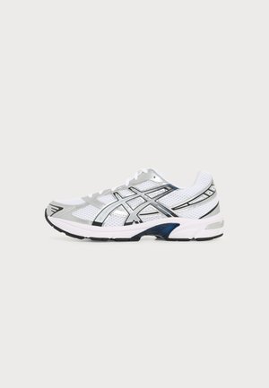 Chaussure de sport en mesh blanc et gris avec des accents noirs et argentés, design à lacets et semelle rembourrée, vue de profil sur un fond uni.
