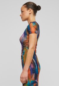 Šarena, uska haljina s kratkim rukavima. Napravljena od rastezljivog materijala u živahnim tie-dye uzorcima narandžaste, plave i zelene boje. Glatka tekstura.