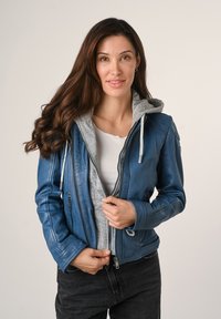Giubbotto in pelle blu con cappuccio grigio, dotato di chiusura con zip sul davanti, tasche laterali e una vestibilità aderente. Texture liscia, stile casual.