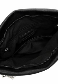Black leather handbag interior, featuring smooth fabric lining, zippered pocket, and an additional slip pocket with a label.
