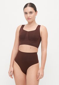Brown bikini set with a cropped top featuring textured ruching and high-waisted bottoms. Smooth material; minimalist design with a square neckline.