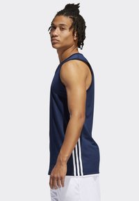 Mørkeblå ærmeløs atletisk tanktop med struktureret overflade, som har hvide stribede kanter på siderne og rund halsudskæring.