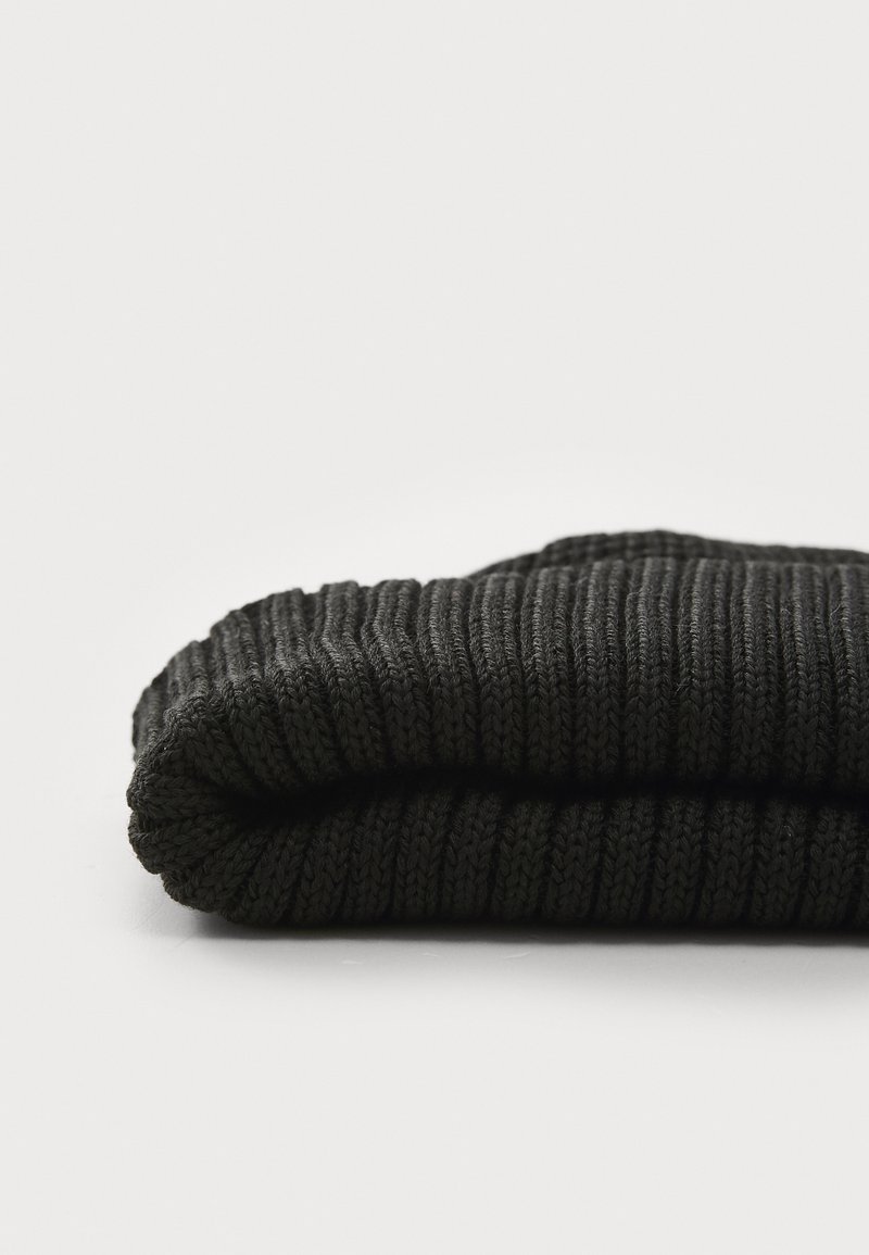 Beanie nera lavorata a maglia, con texture a coste e risvolto. Il materiale è morbido ed elastico, adatto per il freddo.