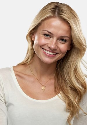 Goldene Halskette mit einem Vogelanhänger, getragen von einer Person mit langen, welligen blonden Haaren, die ein weißes Oberteil trägt und vor einem einfarbigen Hintergrund lächelt.