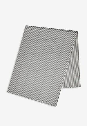 Tela rectangular de rayas finas en blanco y negro doblada sobre un fondo blanco.