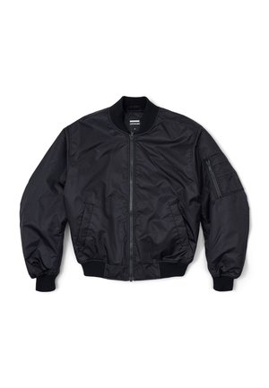 Chaqueta bomber negra hecha de tela suave, con cremallera frontal, cuello acanalado y puños elásticos. Un bolsillo con cremallera en la manga.