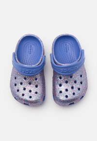 Fialové Crocsy s třpytkami a modrým páskem, vybavené větracími otvory a texturovanou stélkou pro pohodlí.