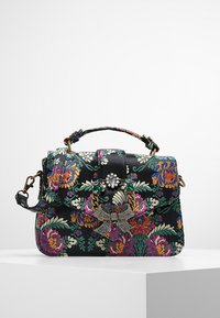 Czarna torebka w kwiaty z kolorowym haftem, złotymi akcentami, dekoracyjną kokardą oraz zapięciem ozdobionym klejnotami. Kompaktowy prostokątny kształt.