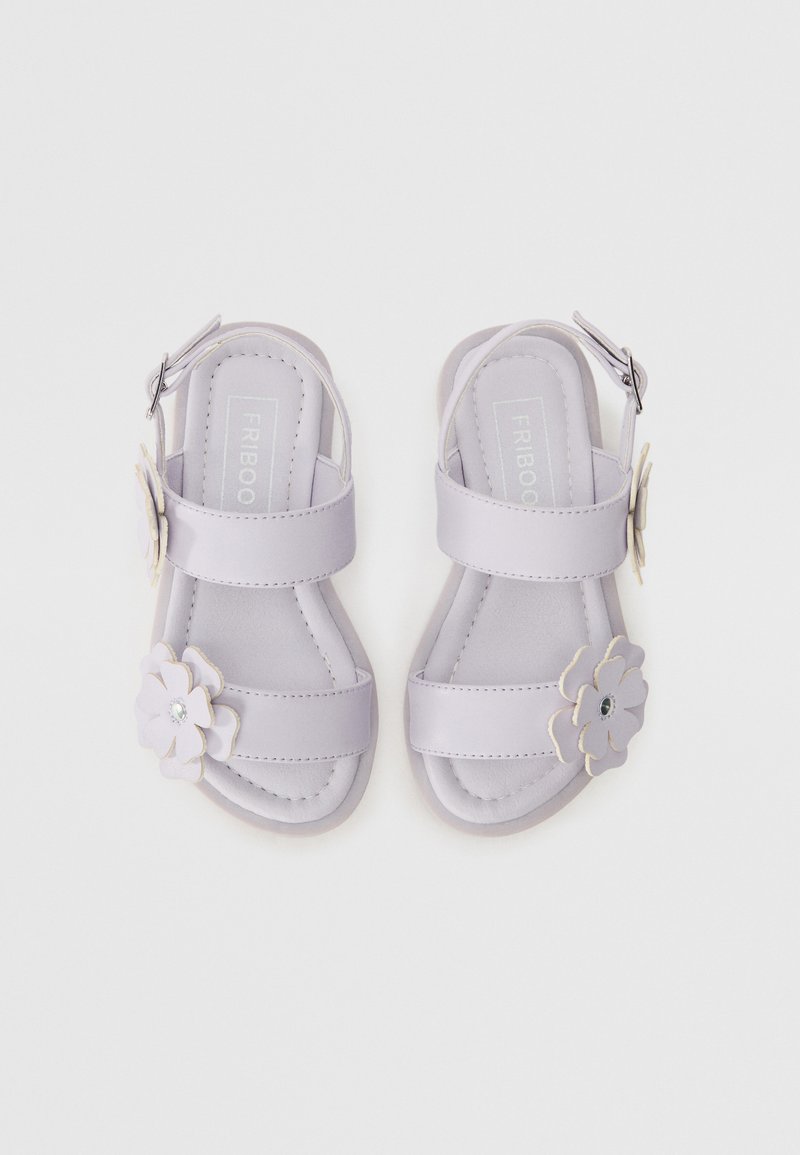 Lilla åpne sandaler med to brede stropper, blomsterdekorasjoner og spenne. Glatt materiale og polstret såle øker komforten.