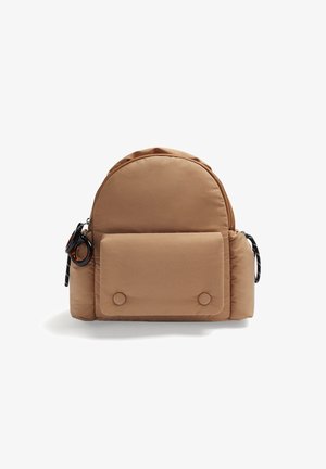 Sac à dos compact couleur sable avec poche avant à rabat, porte-clés rond noir et pochette latérale élastique sur fond blanc.