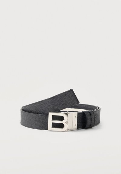 Μαύρη υφασμάτινη δερμάτινη ζώνη τυλιγμένη με ασημένια πόρπη σε σχήμα γράμματος «Β» σε λευκό φόντο.