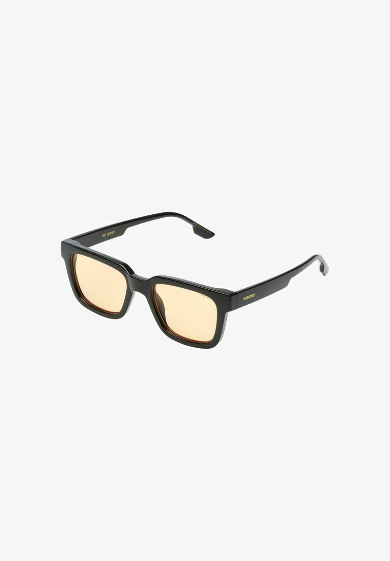 Zwarte vierkante zonnebril met amberkleurige lenzen. Dikke montuur, gladde textuur en gouden merkdetails. Stijlvol, modern ontwerp voor bescherming tegen de zon.