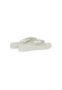 Chanclas de plataforma blancas con textura y tiras plateadas brillantes, vistas desde un ángulo lateral bajo sobre un fondo blanco liso.