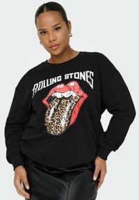 Melnā kapuču džemperis ar Rolling Stones logotipu: sarkanas lūpas ar leoparda rakstu mēli. Mīksta tekstūra ar ribotiem piedurkņu galiem un brīvu piegriezumu.