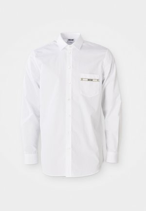 White long-sleeve shirt made of cotton. Features a button-up front, pointed collar, and a small pocket with branding on the chest.
