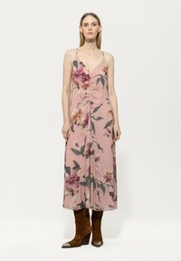 Blumiges Maxikleid aus weichem pinken Stoff mit lila und grünen Mustern, versehen mit einem V-Ausschnitt, verstellbaren Trägern und seitlichem Raffen.
