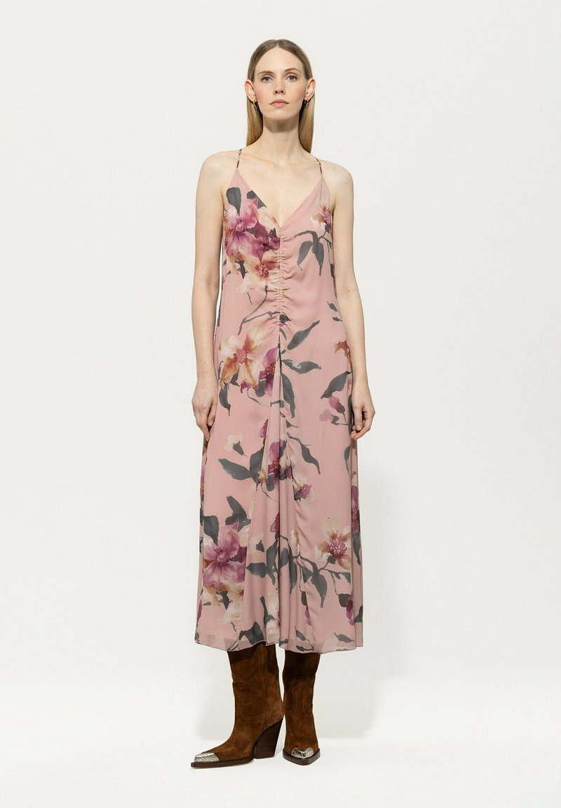 Blumiges Maxikleid aus weichem pinken Stoff mit lila und grünen Mustern, versehen mit einem V-Ausschnitt, verstellbaren Trägern und seitlichem Raffen.