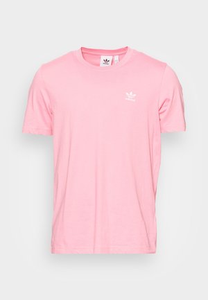 Różowy t-shirt Adidas z krótkim rękawem i okrągłym dekoltem, z małym białym logo trefoil na lewej piersi, prezentowany na jednolitym tle.