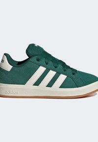 Gröna mockaskor med vit tre-stripes design, med gummisula och texturerade detaljer, märkta med "adidas"-logotypen på tungan.