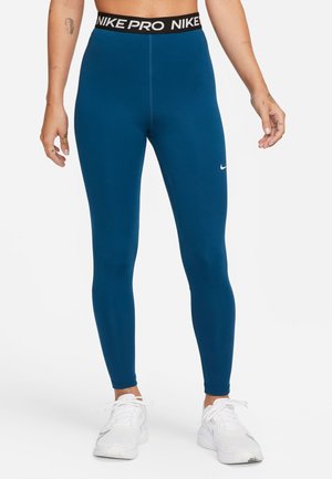 Dopasowane, elastyczne niebieskie legginsy z czarnym pasem oznaczonym "NIKE PRO" w talii i białym logo Nike na dolnej części lewej nogawki.