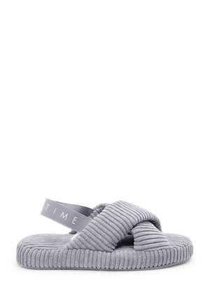 Mocassin gris avec texture nervurée, design croisé et semelle plate. Comprend une tige en tissu doux et une sangle de cheville élastique avec logo.