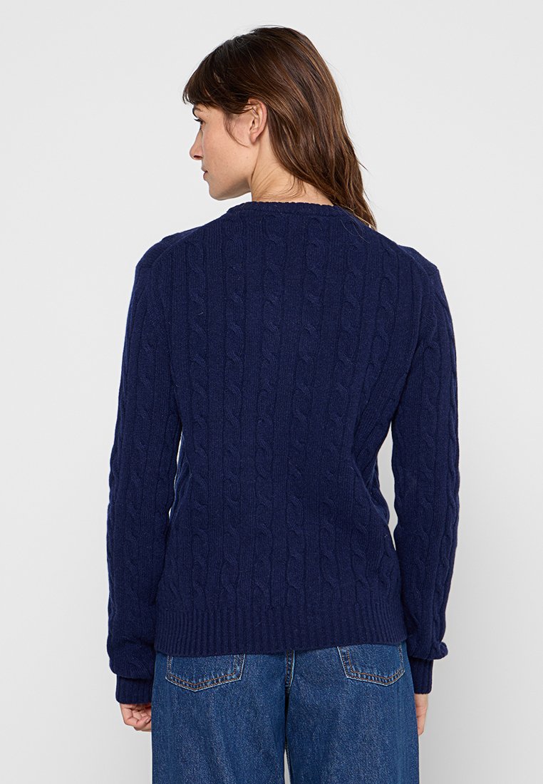 Navyblauer Kabelstrickpullover mit Rundhalsausschnitt und gerippten Bündchen. Dicker, strukturierter Stoff mit einem erhabenen Muster.
