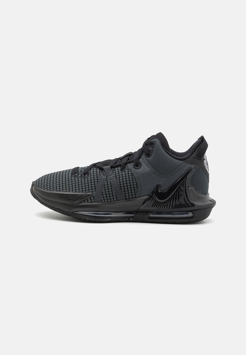 Baskets de sport noires avec empeigne en mesh, semelle rembourrée et grand logo Nike brillant sur le côté.