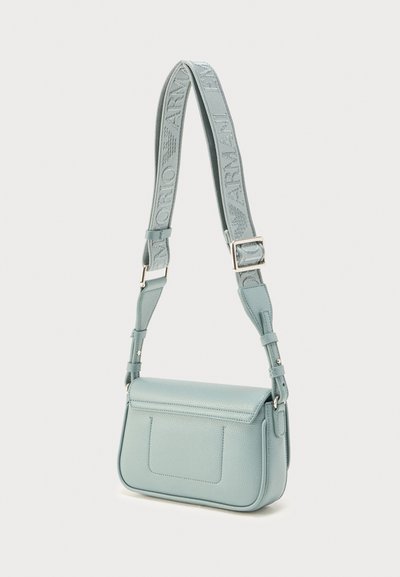 Ελαφρώς γαλάζια δερμάτινη τσάντα χιαστί με ευρύ ρυθμιζόμενο υφασμάτινο λουράκι που διαθέτει ανάγλυφο όνομα και λογότυπο της μάρκας.