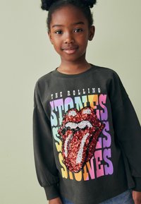 Schwarzer Langarmhoodie mit rotem Pailletten-Logo der Rolling Stones und mehrfarbigem Text. Weicher Stoff mit gerafften Ärmeldetails.
