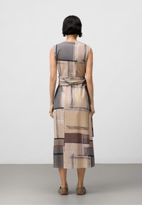 Robe ajustée sans manches avec un motif géométrique mélangé dans des tons beiges, marron et gris ; détail de ceinture à la taille ; design longueur de sol.