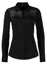 Blouse noire ajustée à manches longues avec boutonnière devant et tissu transparent sur le haut de la poitrine et les épaules.