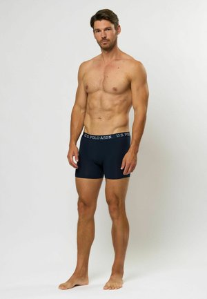 Boxers ajustados en color azul marino para hombre, confeccionados en una tela elástica, que cuentan con una cinturilla elástica de la marca U.S. Polo Assn. y un diseño ceñido.