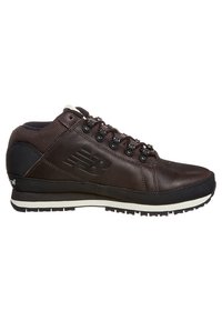 Stivale da trekking in pelle marrone con accenti neri, punta rotonda, sei occhielli, pannelli texture e suola in gomma bianca. Presenta il logo New Balance.