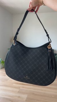 Bolso hobo negro con un patrón texturizado, material de cuero, acentos en dorado, y un borlas decorativa. Correa ajustable para llevar.