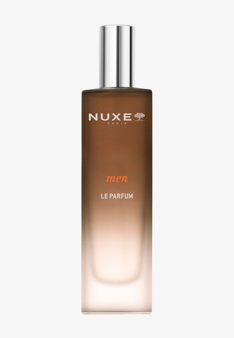 Parfum pour homme NUXE dans un flacon en verre rectangulaire avec un capuchon en métal argenté. Le flacon présente un dégradé du marron au transparent avec un texte en blanc.