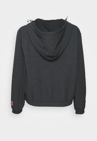 Veste noire texturée à capuche avec manches longues, poignets élastiques et cordons de serrage ajustables sur la capuche, vue de dos sur fond blanc.