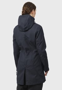 Chaqueta impermeable azul marino con capucha, tejido texturizado, bolsillos con cremallera, dobladillo ajustable y ventilación trasera.