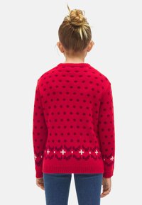 Suéter de punto rojo con un patrón de lunares y acentos blancos. Puños y dobladillo acanalados con un borde decorativo en la parte inferior.