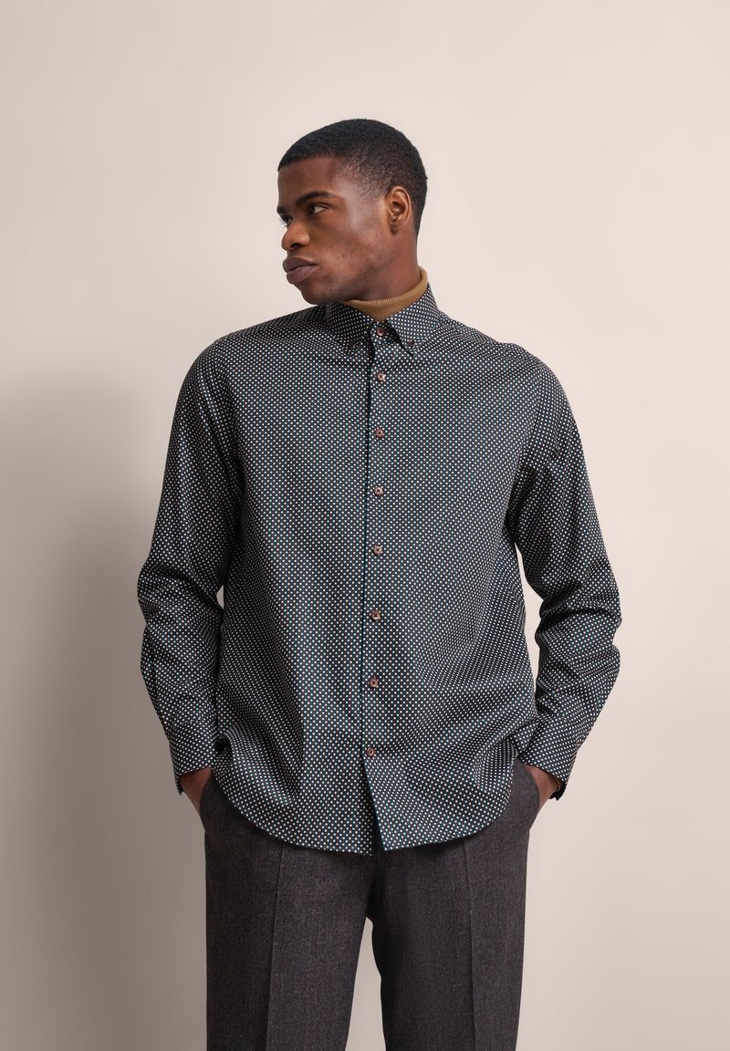 Langärmliges Hemd mit Knopfleiste in Marineblau mit weißen Punkten, mit abgerundetem Saum, Spread-Kragen und kontrastierenden Knöpfen.