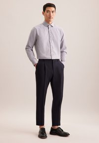 Herren karierte Hemd mit Knöpfen, lange Ärmel, marineblaue maßgeschneiderte Hose, schwarze Dressschuhe, glatte Textur, taillierte Passform, klare Linien.